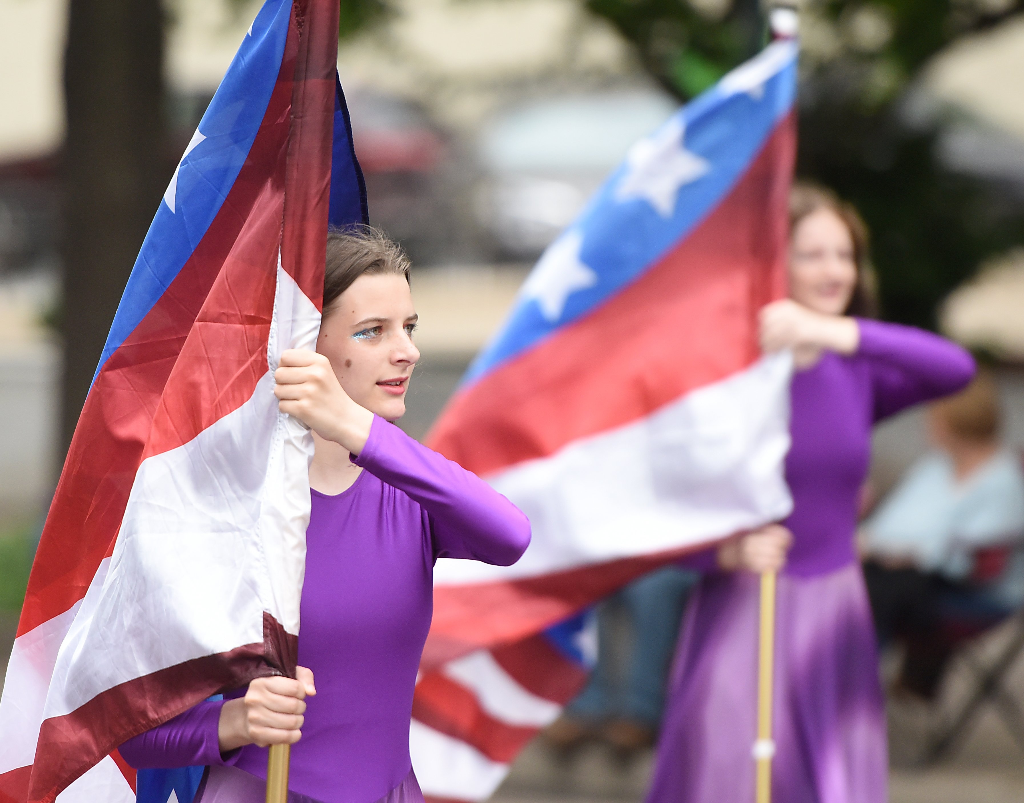 Staff photo by Matt Hamilton/ Sequatchee County High School marching band color guard member Meadow Norberg, 14, carries a flag on Market Street during the 75th Armed Forces Day Parade on Friday, May 3, 2024.