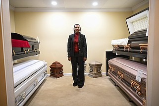 Kenya Richardson, director of Premier Funeral Home in Little Rock, stands in a display room for caskets available at the funeral home.
(Arkansas Democrat-Gazette/Stephen Swofford)