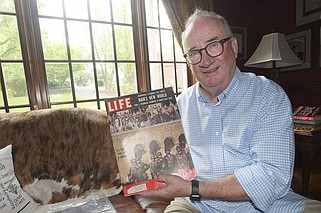 David Matthews holds up a copy of Life magazine from 1957 with a cover photo of federal troops in front of Little Rock Central High School and addressed to the late Arkansas Gov. Orval Faubus. The issue will be appraised during a “Antiques Roadshow” stop in Bentonville.
(NWA Democrat-Gazette/Flip Putthoff)