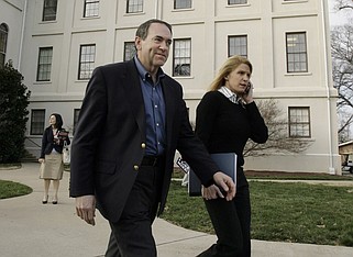 Alice Stewart (right), then the campaign press secretary for former Arkansas Gov. Mike Huckabee (left), walks with the then-presidential hopeful as he goes to a live television interview at a campaign stop at Wofford College in Spartanburg, S.C., in this Jan. 18, 2008 file photo. (AP/Alex Brandon)