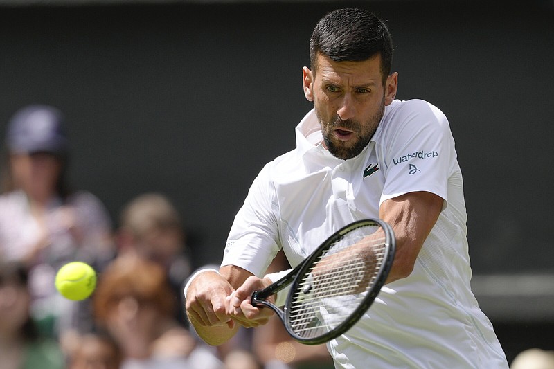 Novak Djokovic of Serbia hits a backhand return Thursday during his four-set victory over Britain’s Jacob Fearnley in second-round men’s singles action at Wimbledon. Djokovic’s surgically repaired right knee was pain-free during the match, but the movement that has been key to his success in the past is not yet back to normal.
(AP/Kirsty Wigglesworth)