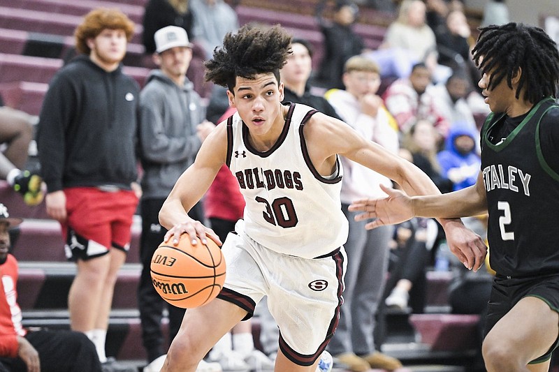 Springdale guard Isaiah Sealy (30) drives past Kansas City Staley guard Jakobe Hicks during a game Friday, Dec. 15, 2023, in Springdale. (Charlie Kaijo/NWA Democrat-Gazette)