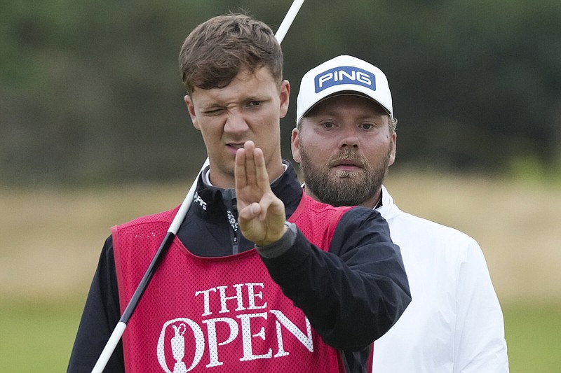 England’s Daniel Brown (back) looks over his caddie’s shoulder Thursday as they line up a putt on the 12th hole during the opening round of the 152nd British Open at Royal Troon Golf Club in Troon, Scotland. Brown shot a 6-under 66 and leads the tournament by one shot over Shane Lowry of Ireland.
(AP/Jon Super)