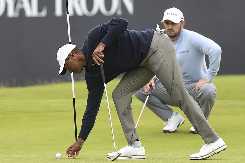 Tiger Woods of the United States places his ball on the 18th green Friday during his second round of the British Open at Royal Troon golf club in Troon, Scotland.
(AP/Scott Heppell)