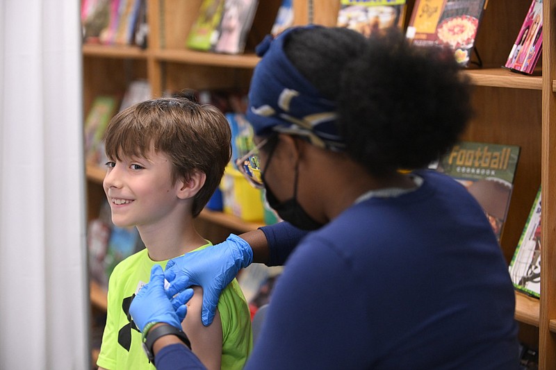 Liam Cucciare receives his flu shot from Zhaiven Nelson, a registered nurse for the Arkansas Department of Health, during the flu immunization clinic at Jefferson Elementary School in Little Rock in this Oct. 13, 2023, file photo. (Arkansas Democrat-Gazette/Staci Vandagriff)