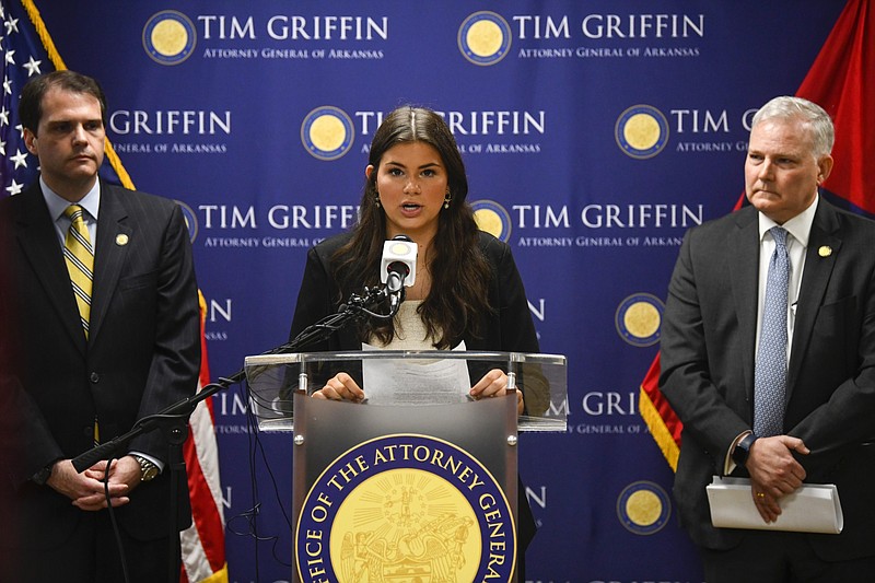 Amelia Ford (center), a 10th grader at Brookland High School, stands between Arkansas Solicitor General Nicolas Bronni (left) and Arkansas Attorney General Tim Griffin as she makes a statement during a news conference in Little Rock in this May 7, 2024, file photo. Ford was speaking on a lawsuit on behalf of four other states against the U.S. Department of Education over its update to Title IX regulations that included protections for transgender people and other members of the LGBTQ community in those states. (Arkansas Democrat-Gazette/Stephen Swofford)