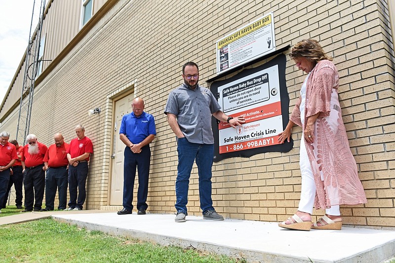 Pastor Oliver Thomas (center) of East End Baptist Church blesses the new Safe Haven Baby Box with Monica Kelsey, founder of Safe Haven Baby Boxes, at the East End Fire Department south of Little Rock on Wednesday, July 24, 2024. (Arkansas Democrat-Gazette/Staci Vandagriff)