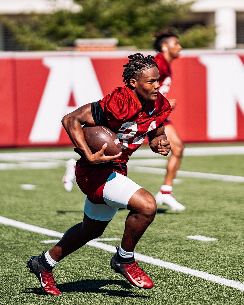 Freshman defensive back Tevis Metcalf runs with the ball during a practice at the University of Arkansas. Metcalf joined his brother TJ Metcalf, a sophomore with the Razorbacks, and enrolled at Arkansas in January.
(Arkansas Athletics)