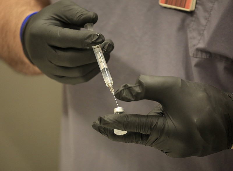 Nurse Charles Brenke with Wellpath, the contracted medical provider for the Arkansas Department of Corrections, prepares doses of the Pfizer covid-19 vaccine in North Little Rock in this Jan. 5, 2021, file photo. Employees of the Corrections Department and Wellpath were among the first in Arkansas to get the vaccine. (Arkansas Democrat-Gazette/Staton Breidenthal)