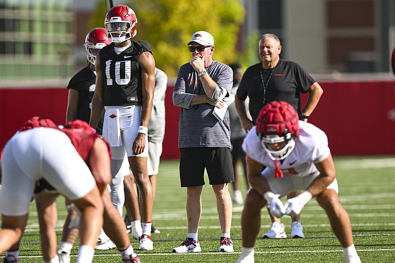 Arkansas quarterback Taylen Green (10) looks over the defense Wednesday as offensive coordinator Bobby Petrino (center) and Coach Sam Pittman look on during the Razorbacks’ first preseason practice in Fayetteville. Pittman said things started slowly but got better as the day went on. “I thought inside run was a little slow. I don’t think we were chasing the ball like we want to chase the ball, but I thought after the first break it picked up for us,” Pittman said.
(NWA Democrat-Gazette/Hank Layton)