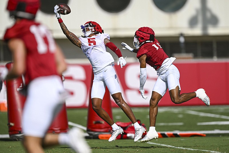 Arkansas wide receiver Tyrone Broden (left) makes a one-handed catch as defensive back Jaylon Braxton defends during practice Wednesday in Fayetteville.
(NWA Democrat-Gazette/Hank Layton)