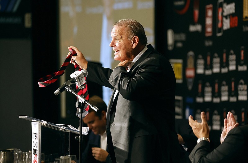 Arkansas Razorbacks head coach Sam Pittman removes his tie saying he wore the same tie last year and didn’t “want a repeat of last year,” during the Little Rock Touchdown Club meeting on Monday, Aug. 19, 2024, at the DoubleTree Hotel in Little Rock.  .(Arkansas Democrat-Gazette/Thomas Metthe)