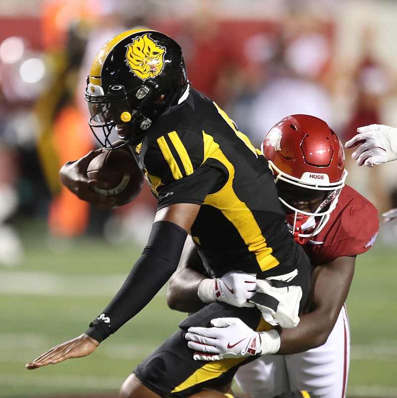 Arkansas linebacker Bradley Shaw (7) tackles Arkansas-Pine Bluff quarterback Mekhi Hagens (9) for a loss during the fourth quarter of the Razorbacks’ 70-0 win on Thursday, Aug. 29, 2024, at War Memorial Stadium in Little Rock. (Arkansas Democrat-Gazette/Thomas Metthe)