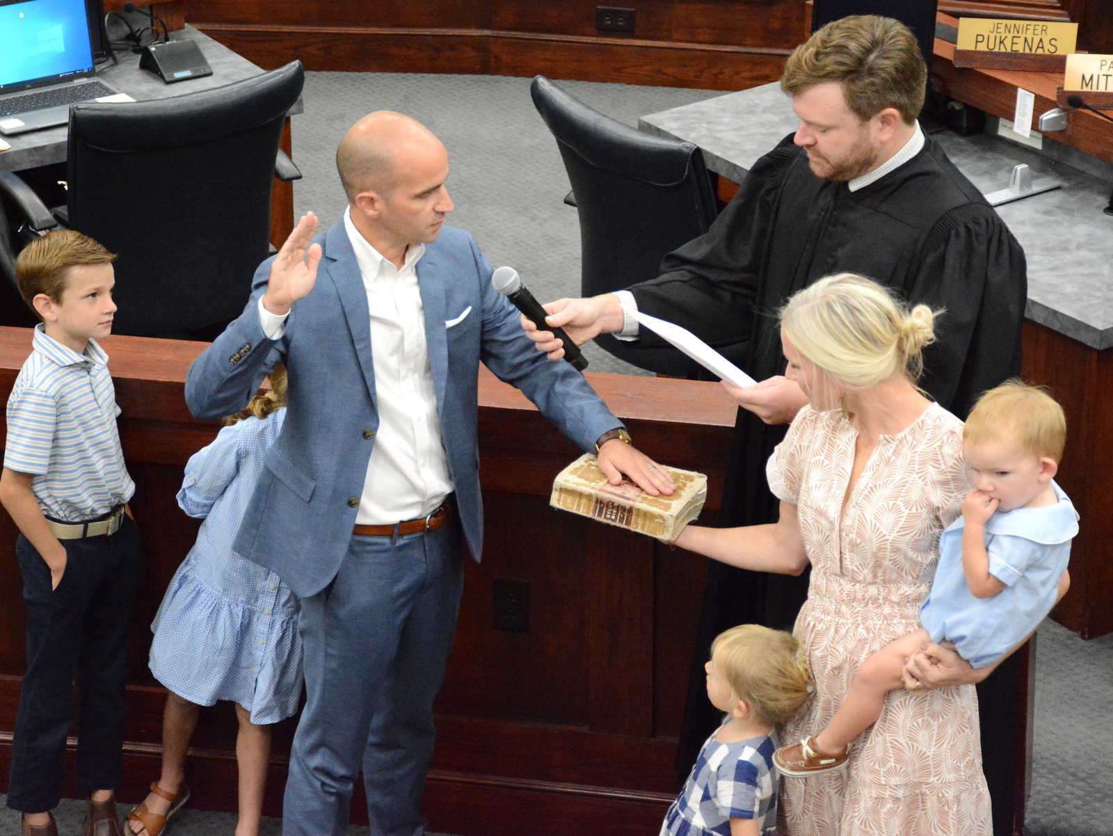 Staff Photo by Robin Rudd / Hamilton County Circuit Court Judge Alex McVeagh, upper left, administers the oath of office to Ben Daugherty, as wife Anna Daugherty holds the Bible. The Daugherty’s were joined by their four children. The six members of the Hamilton County school board who were elected in August were sworn in and administered their Oaths of Office on September 4, 2024. The members were Steve Slater, Ben Daugherty, Jackie Anderson-Thomas, Jodi Schaffer, Felice Hadden and Jill Black.