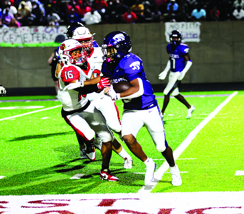 El Dorado's Josiah Moore tries to avoid a tackle attempt by Camden Fairview's Zakilan Marks. The Wildcats beat the Cardinals 35-34 Friday at Memorial Stadium.