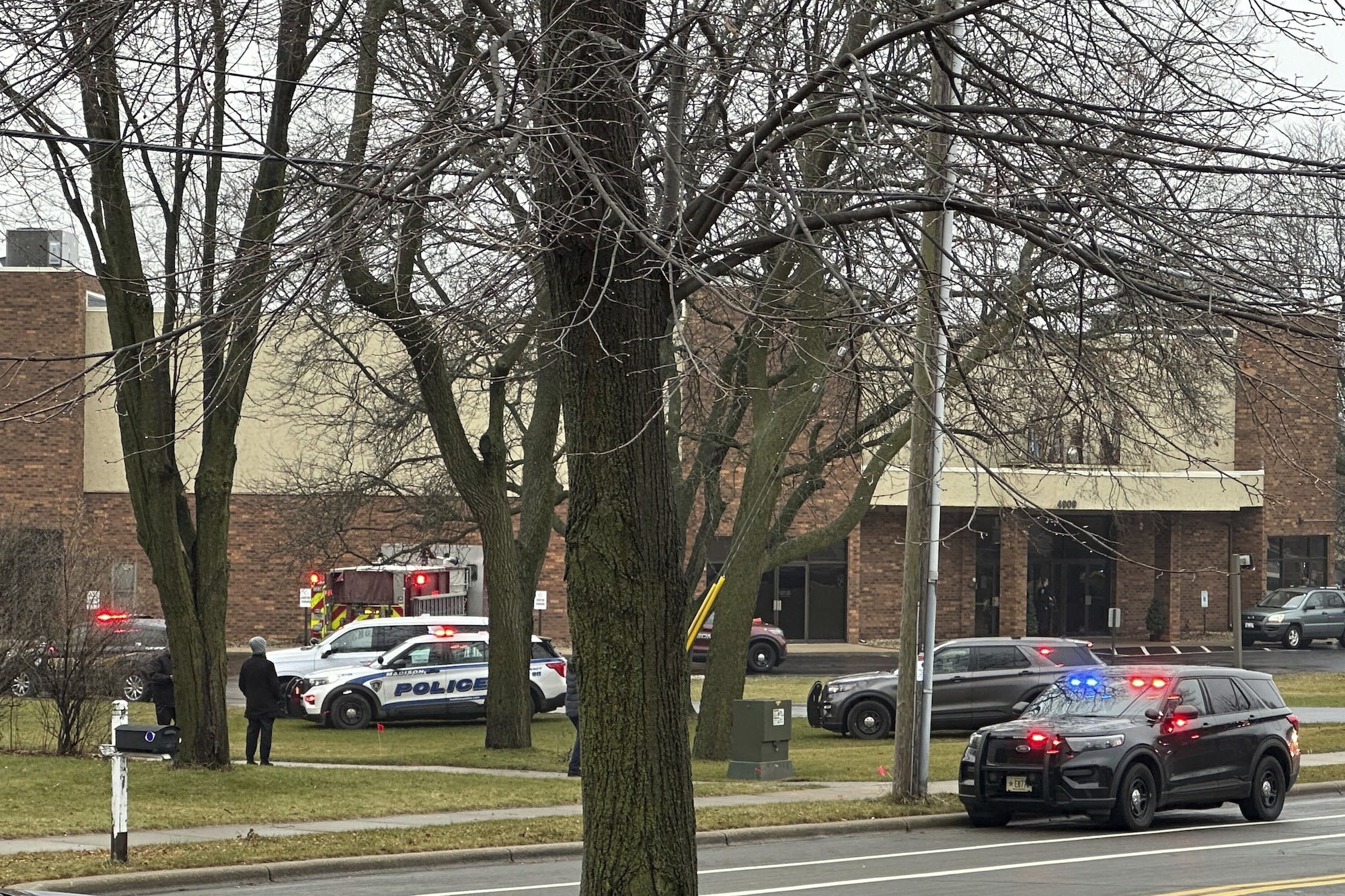 Emergency vehicles are parked outside the Abundant Life Christian School in Madison, Wis., where multiple injuries were reported following a shooting, Monday, Dec. 16, 2024. (AP Photo/Scott Bauer)
