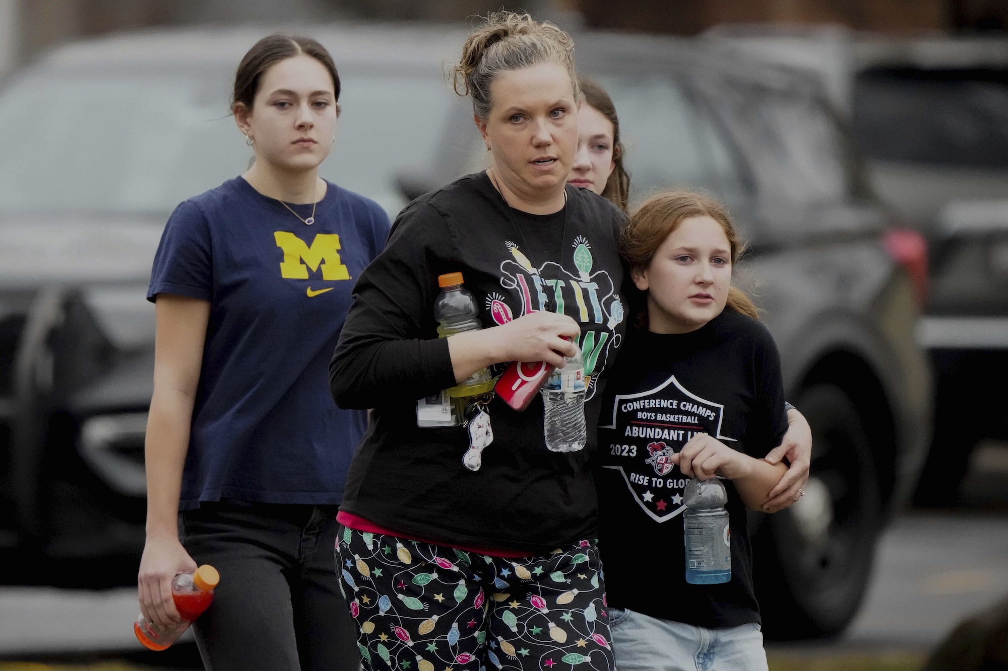 A family leaves the Abundant Life Christian School after a shooting, Monday, Dec. 16, 2024. (AP Photo/Morry Gash)