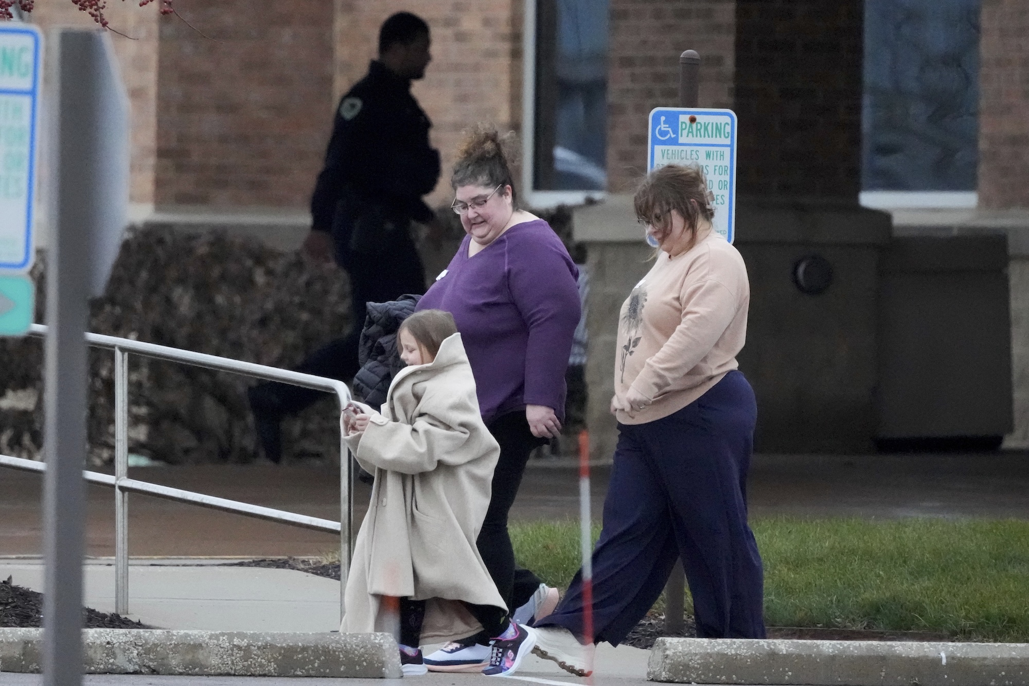 A family leaves the SSMI Health Center, set up as an reunification center, in Madison, Wis., following a shooting, Monday, Dec. 16, 2024. (AP Photo/Morry Gash)