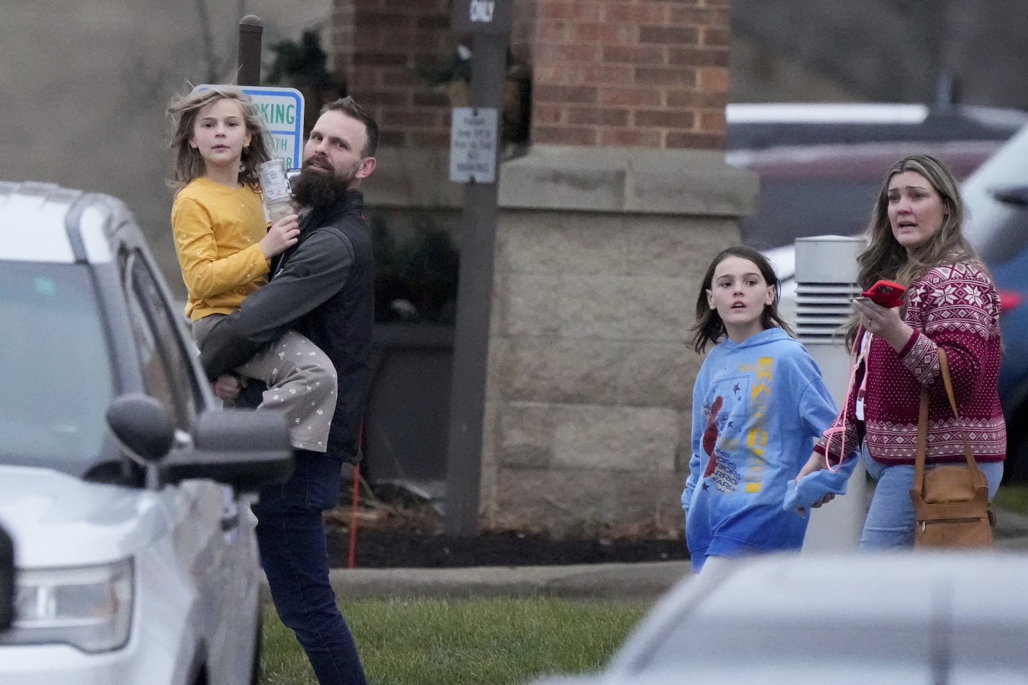 Families leave the SSMI Health Center, set up as a reunification center, following a shooting, Monday, Dec. 16, 2024 in Madison, Wis. (AP Photo/Morry Gash)