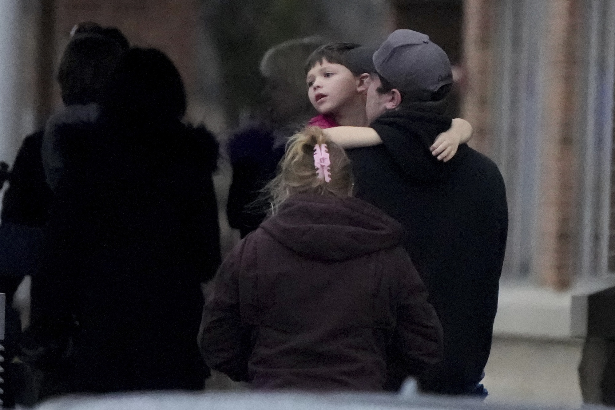 A child is embraced at the SSMI Health Center, set up as a reunification center, following a shooting, Monday, Dec. 16, 2024 in Madison, Wis. (AP Photo/Morry Gash)