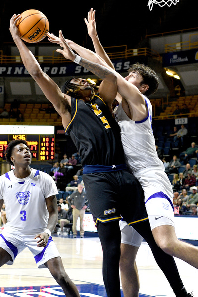 Staff Photo by Robin Rudd / UTC’s Frank Champion (5) is fouled by Wesleyan’s Amando Caurdado (22). The University of Tennessee at Chattanooga Mocs hosted the Tennessee Wesleyan Bulldogs at McKenzie Arena on December 18, 2024.