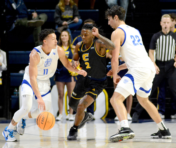 Staff Photo by Robin Rudd / UTC;s Trey Bonham (2) guards Wesleyan’s Amauri Young (11), as he avoids the pick of Amando Caurdado (22). . The University of Tennessee at Chattanooga Mocs hosted the Tennessee Wesleyan Bulldogs at McKenzie Arena on December 18, 2024.