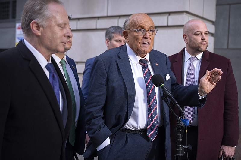 Rudy Giuliani, center, speaks to reporters after leaving federal court in Washington, Friday, Jan. 10, 2025. (AP Photo/Mark Schiefelbein)