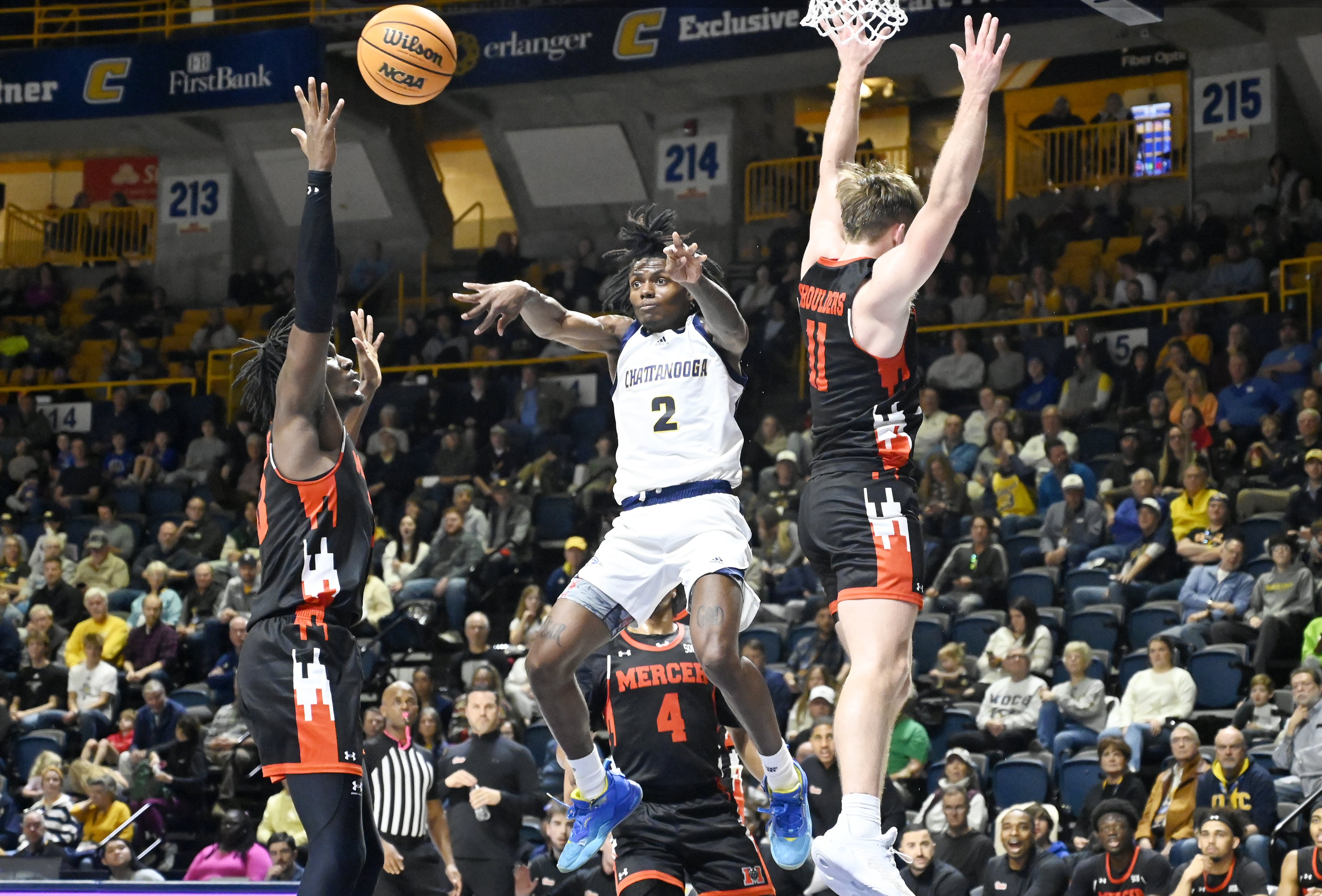 Staff photo by Abby White / Trey Bonham, 2, passes the ball by jumping to avoid Mercer defense. The University of Tennessee at Chattanooga Men’s Basketball team played Mercer on Saturday, February 1, 2025 in McKenzie Arena.