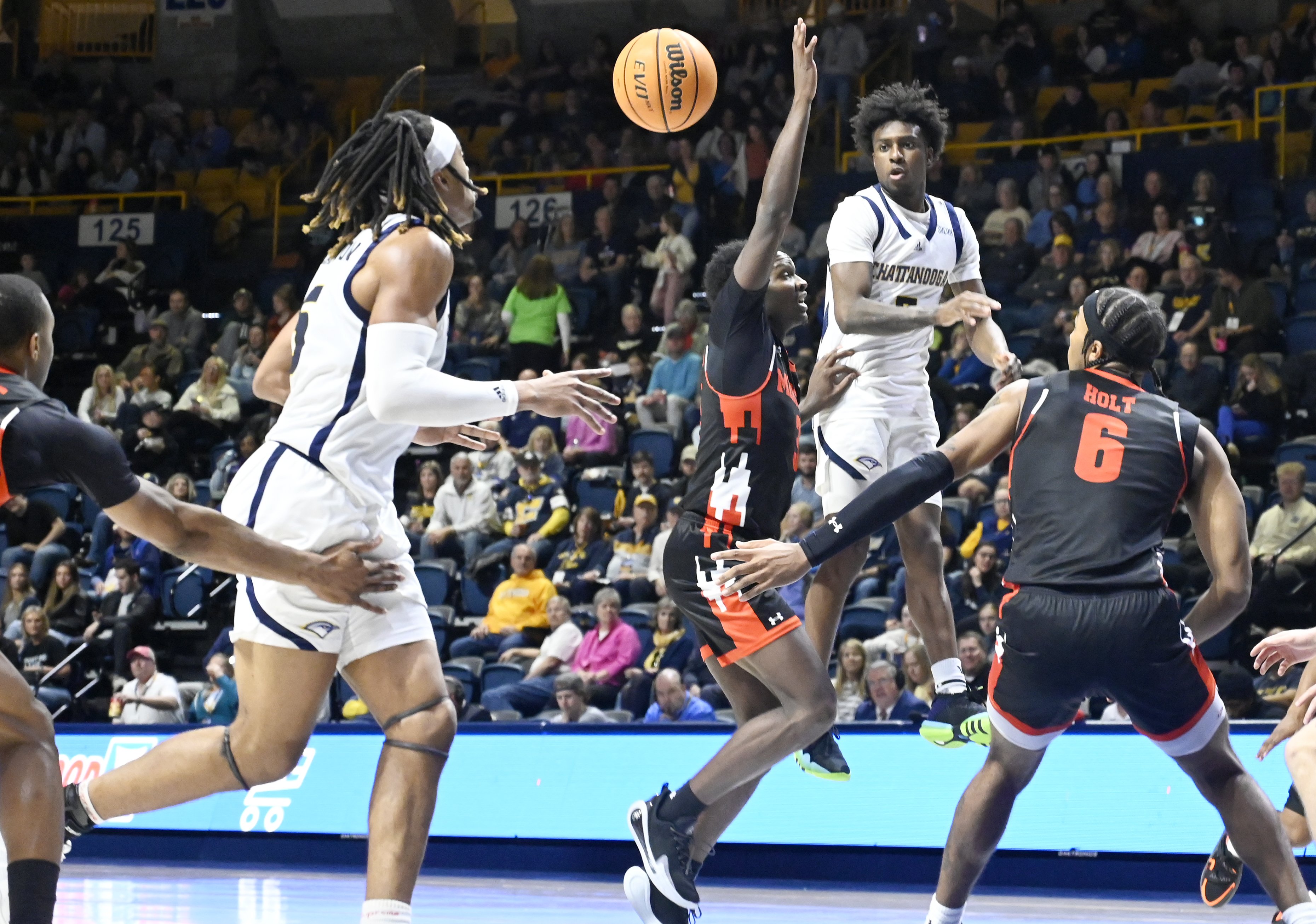 Staff photo by Abby White / Honor Huff, 3, passes the ball to Frank Champion, 5, by jumping to avoid Mercer defense. The University of Tennessee at Chattanooga Men’s Basketball team played Mercer on Saturday, February 1, 2025 in McKenzie Arena.