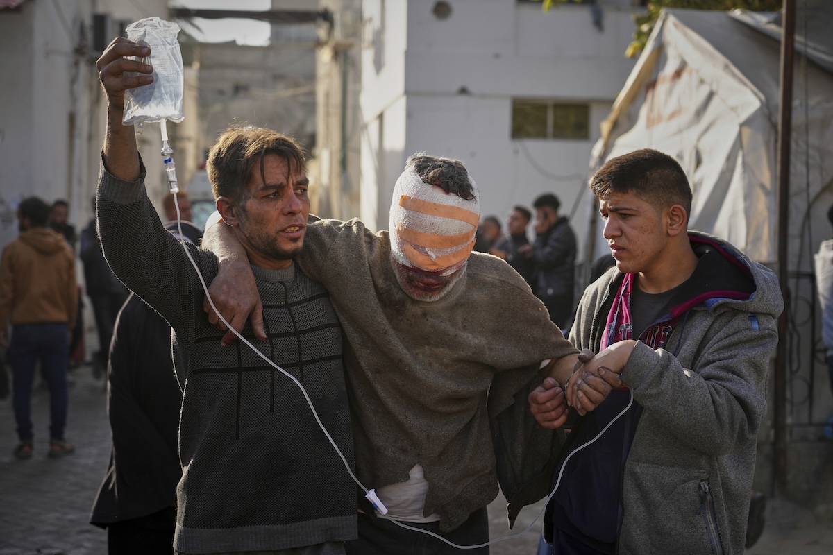 An injured man is taken to the Al-Ahli hospital following overnight Israeli army airstrikes across the Gaza Strip, in Gaza City, Tuesday, March 18, 2025. (AP Photo/Jehad Alshrafi)