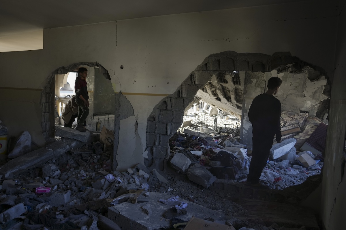 Palestinians inspect the damage at Al-Tabi'in School in central Gaza Strip following an Israeli airstrike, Tuesday, March 18, 2025. (AP Photo/Jehad Alshrafi)
