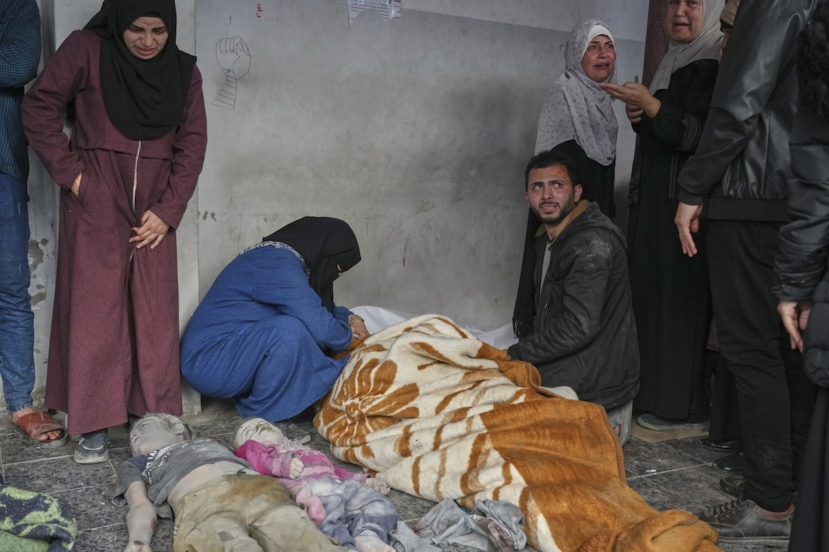 EDS NOTE: GRAPHIC CONTENT - A woman mourns over the body of a person killed in overnight Israeli army airstrikes across the Gaza Strip, at the Al-Ahli hospital in Gaza City, Tuesday, March 18, 2025. (AP Photo/Jehad Alshrafi)