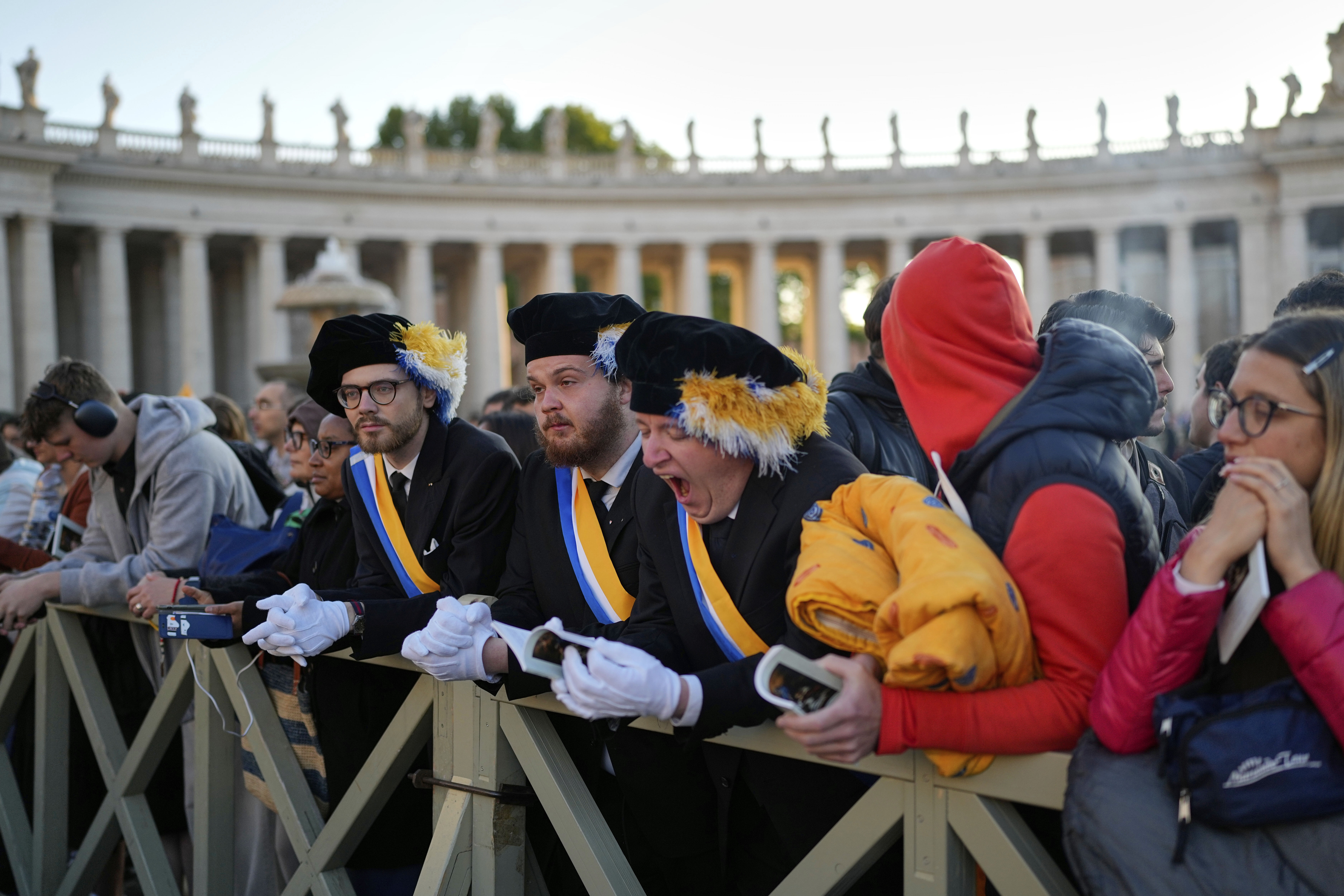 A man yawns as people arrive in St. Peter's Square ahead of the funeral of Pope Francis at the Vatican, Saturday, April 26, 2025. (AP Photo/Andreea Alexandru)