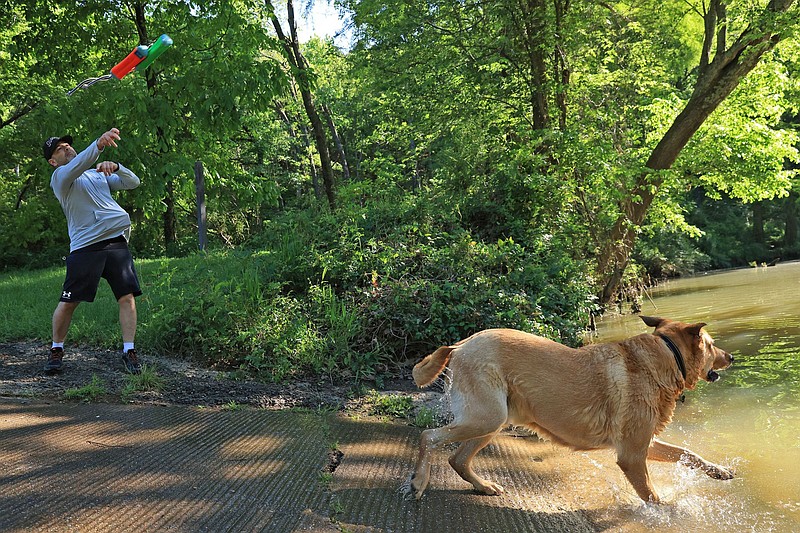 Michael Bilotti plays fetch with his dog Buddy at a boat landing in Pinnacle Mountain State Park on Sunday, May 4, 2025. (Arkansas Democrat-Gazette/Colin Murphey)