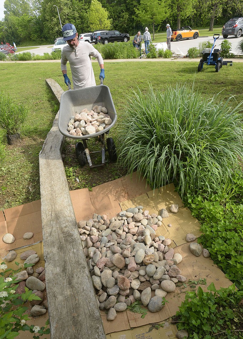 Brandon Mathis unloads rock Saturday May 10 2025 at the Lake Springdale trailhead rain garden..(NWA Democrat-Gazette/Flip Putthoff)