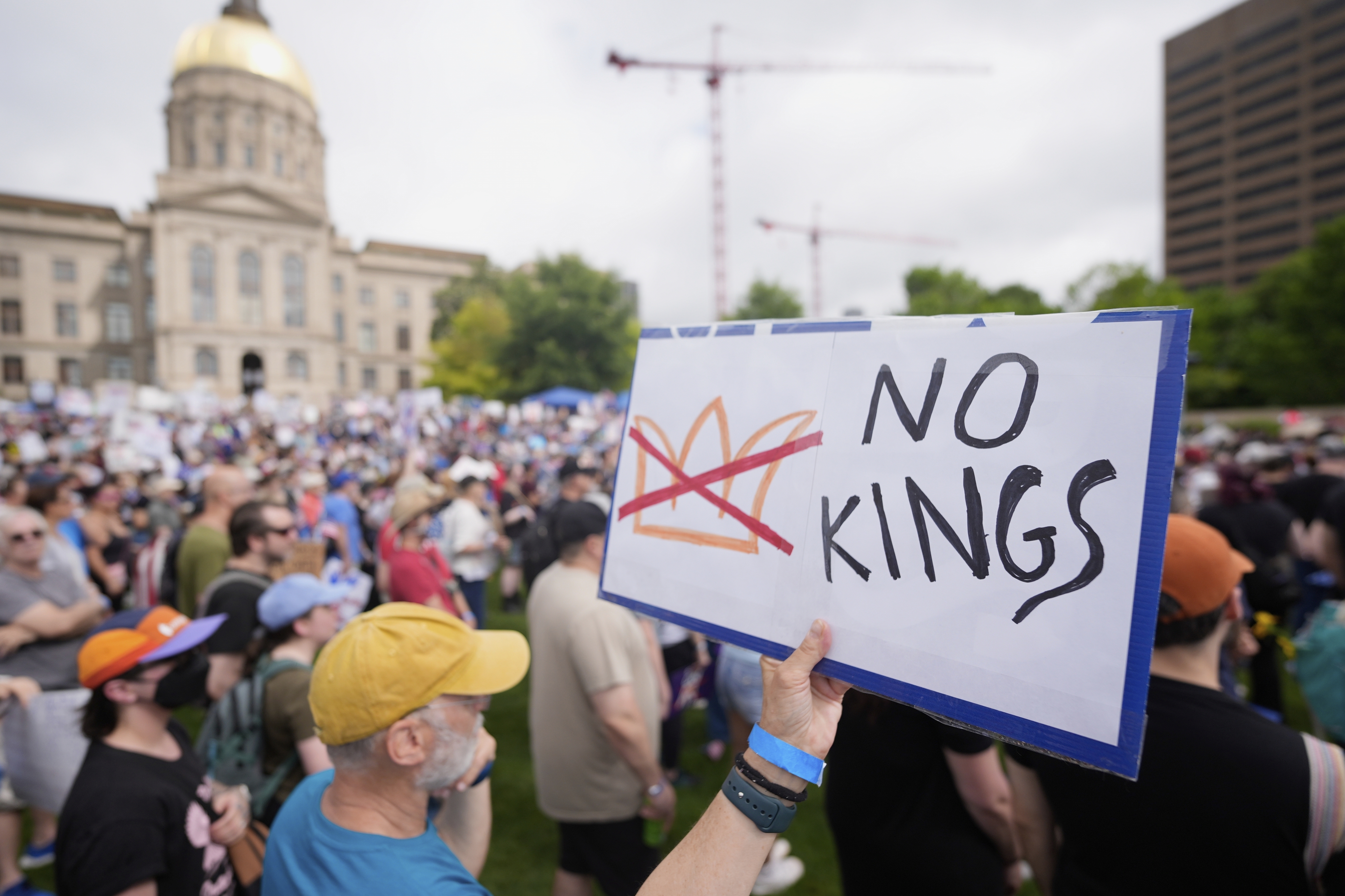 A demonstrator holds a sign during a "No Kings" protest, Saturday, June 14, 2025, in Atlanta. (AP Photo/Mike Stewart)