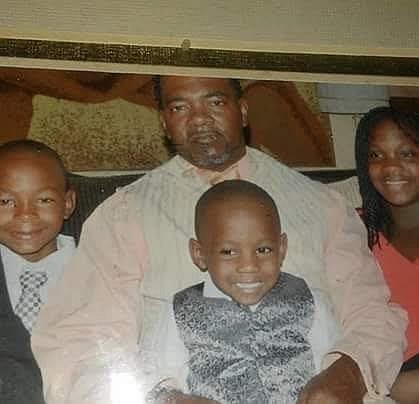A young Floyd Cornell Allen III (center) sits in his father's lap, surrounded by his siblings, in this undated courtesy photo. (Special to The Commercial)