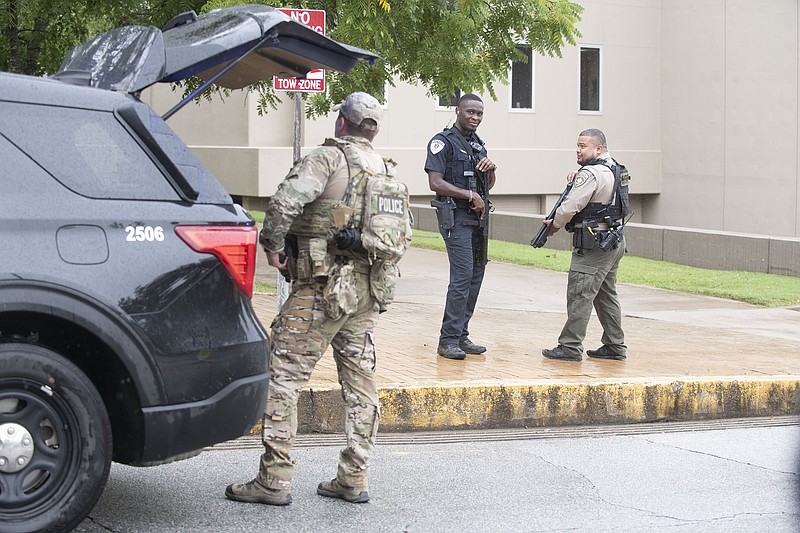 Law enforcement personnel stage near the law school Monday Aug. 25, 2025 at the University of Arkansas in Fayetteville after reports of an active shooter near Mullins Library Visit nwaonline.com/photo for today's photo gallery. (NWA Democrat-Gazette/J.T. Wampler) ..