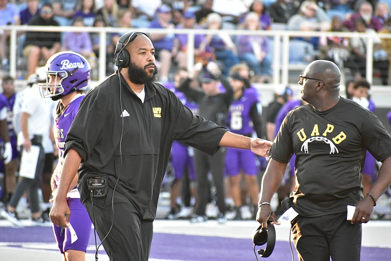 UAPB offensive coordinator Tony Hull separates Coach Alonzo Hampton from an official off-camera during an injury timeout in the first half. (Pine Bluff Commercial/I.C. Murrell)