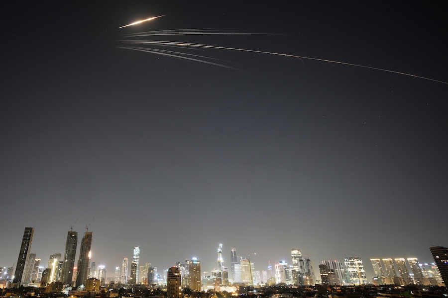 Missiles launched from Iran streak across the sky over central Israel, Wednesday, March 18, 2026. (AP Photo/Ohad Zwigenberg)