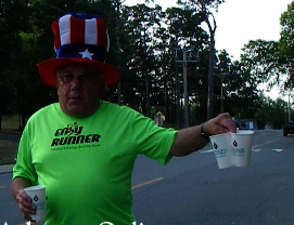 Steve Eubanks explains how volunteers should offer water to runners at the 36th annual Firecracker Fast 5K's only water stop.

