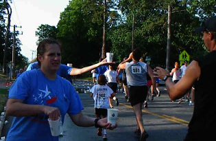 Steve Eubanks and Hobbit and Tom Singleton's Little Rock Marathon team keep runners hydrated at the 36th annual Firecracker Fast 5K's only water stop.
