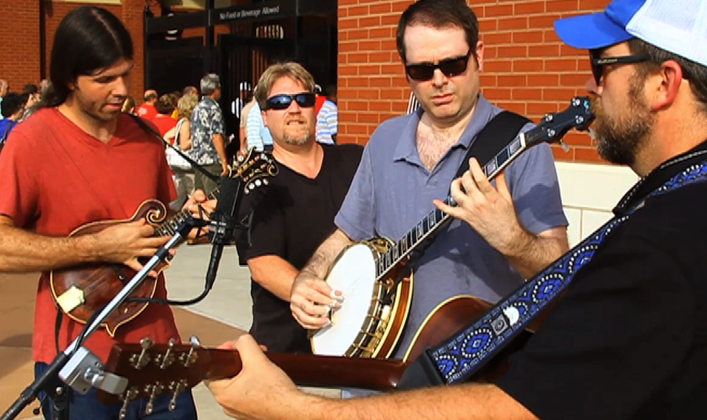 Members of the band Runaway Planet, Matthew Stone, Michael Proveaux, Steve
Brauer and Greg Alexander, sing outside Dickey-Stephens Park Friday evening
before the Arkansas Travelers' game.