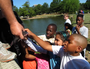 A small crowd of children watched as 1,500 catfish were added to the pond at MacArthur Park for the annual fishing derby there Thursday.