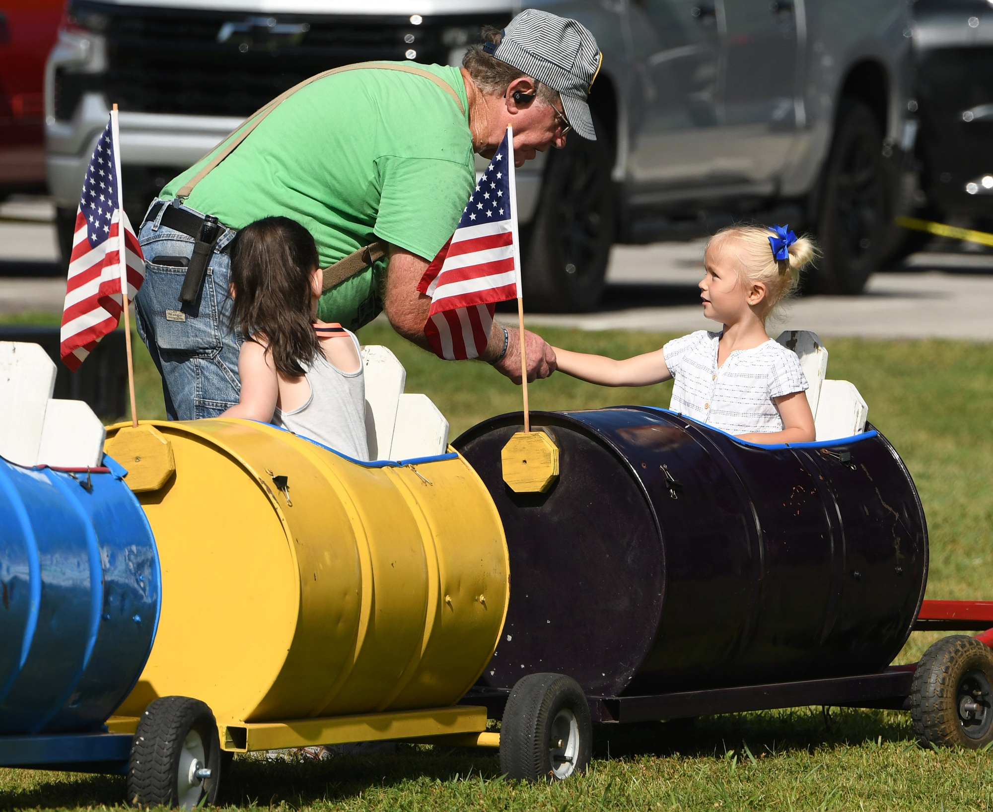 Staff Photo by Robin Rudd / Glenn Leming, who drives Oak Street Baptist's Trinity Railway train, greets one of his young passengers before a round around the park. The Soddy-Daisy Independence Celebration was hosted by the Vietnam Veterans of America Soddy-Daisy Chapter 942 at Soddy Municipal Park on July 6, 2024. The event once again featured the popular car show.