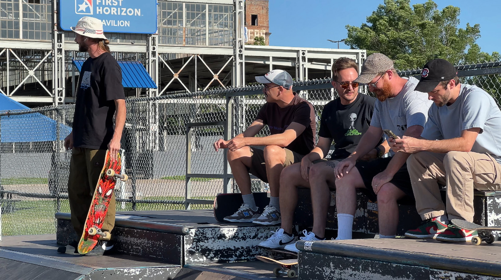 Staff photo by Cassandra Castillo / From left, Ryan Cooper, Reed Levine, Harris Oates, Mark Stewart and Brandon Ormsby talk between sets on May 21, 2025. The Chattanooga Skate Park renovation has been postponed for the second time, drawing concerns from the skater community.