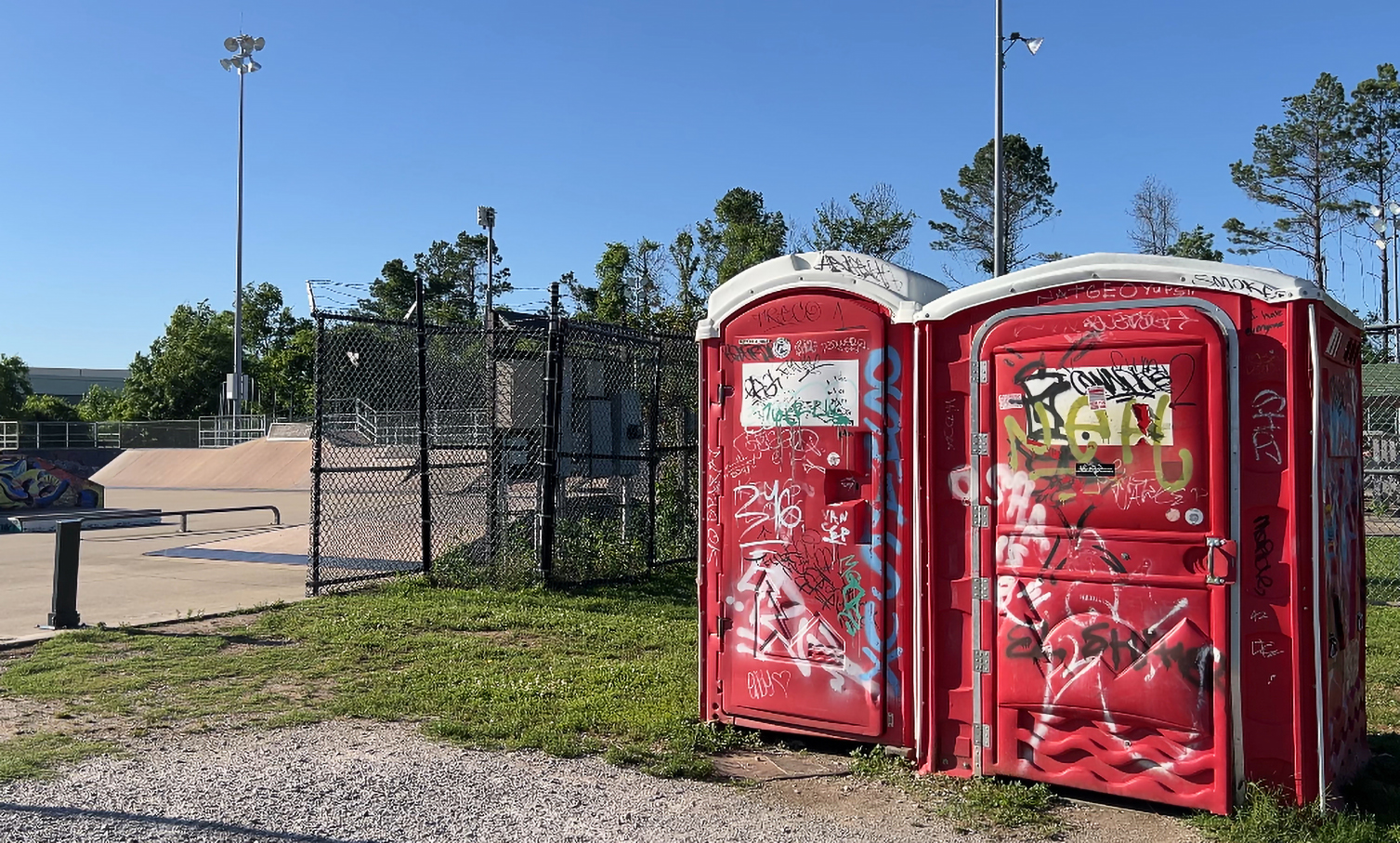Staff photo by Cassandra Castillo / The sole bathroom station at the Chattanooga Skate Park is two portables with graffiti on May 21, 2025. The park renovation has been postponed for the second time, drawing concerns from the skater community.