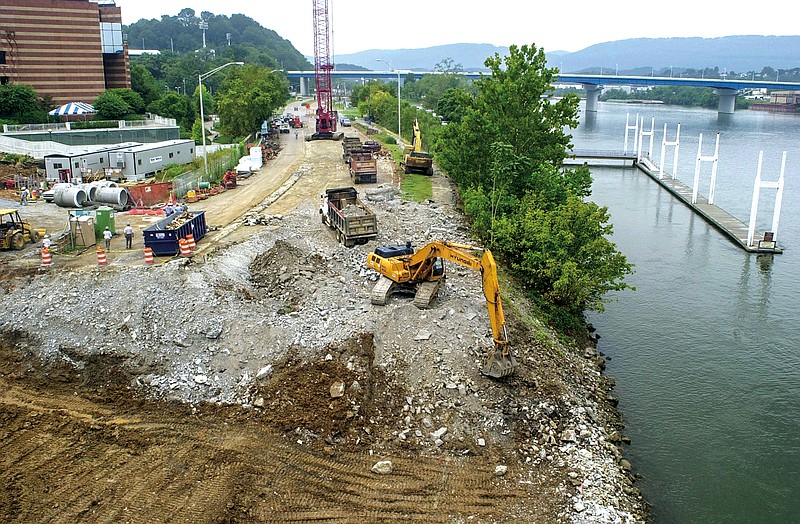 Staff file photo / A track hoe digs into the bank of the Tennessee River in 2003 as construction continues on a ramp to the river as part of a Trail of Tears memorial next to the new Tennessee Aquarium building, also under construction nearby.