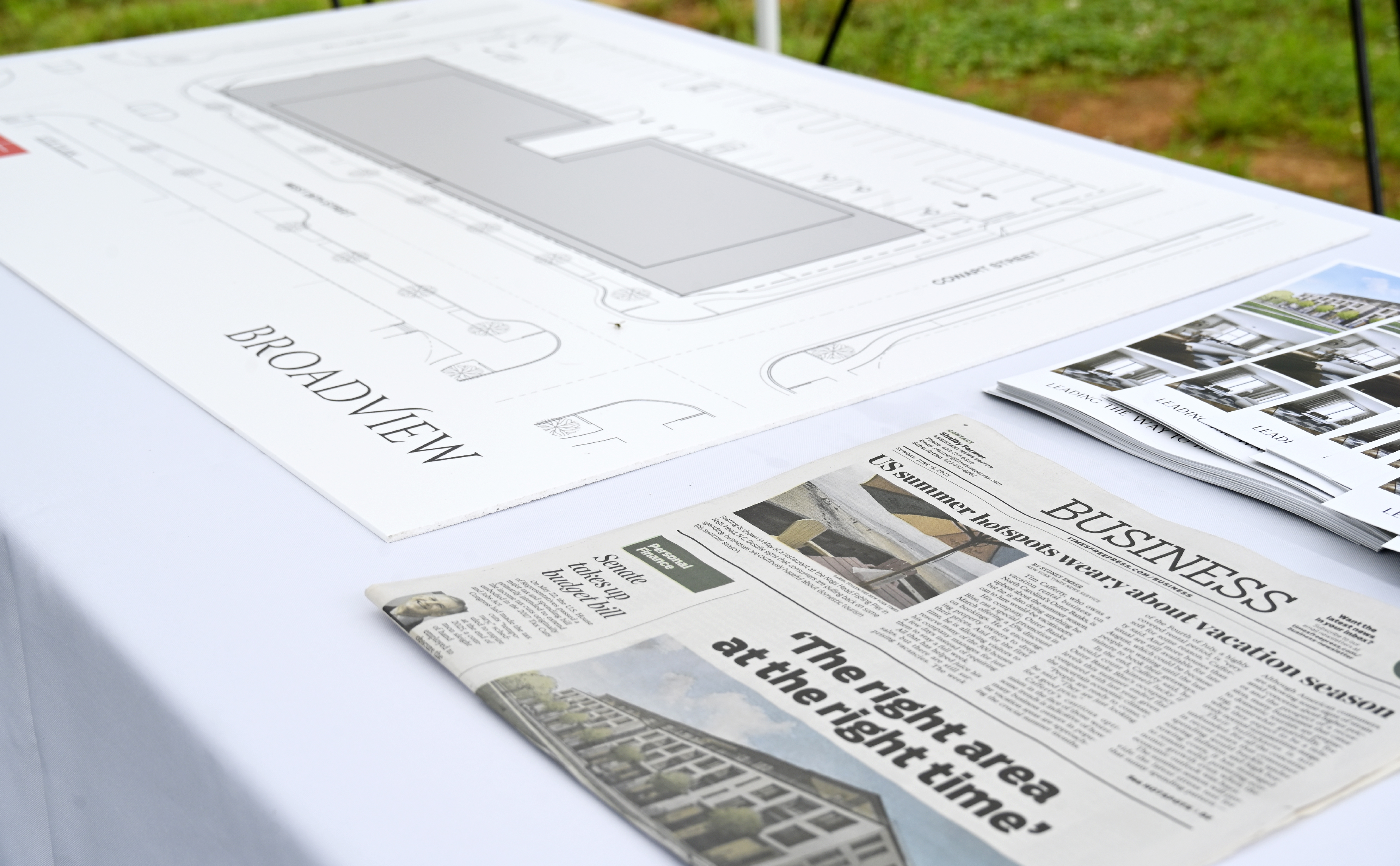 Staff photo by Abby White / A blueprint, newspaper article and renderings of the new Broadview development are displayed at a groundbreaking ceremony June 16, 2025.
