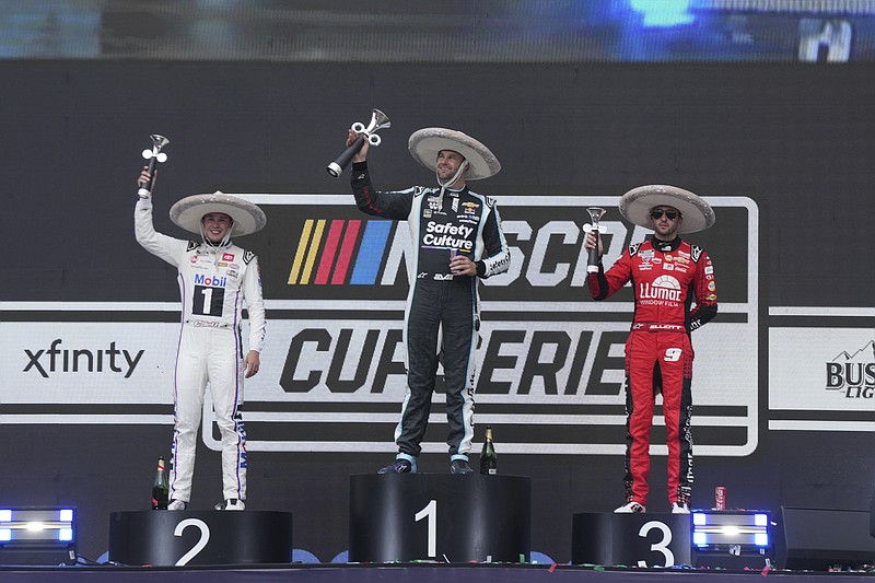 Shane Van Gisbergen, center, celebrates at the Victory Lane after winning a NASCAR Cup Series auto race with second place Christopher Bell, left, and third place Chase Elliott at Hermanos Rodríguez race track in Mexico City, Sunday, June 15, 2025. (AP Photo/Fernando Llano)